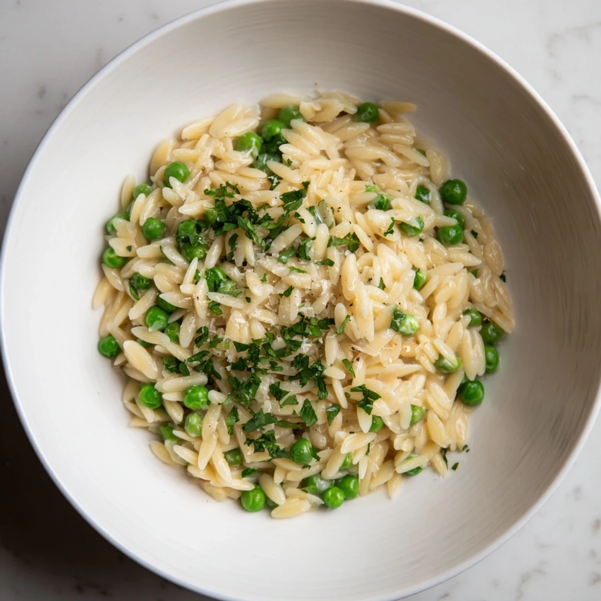 Up-close shot of Parmesan orzo with peas, showing the rich sauce and tender pasta.