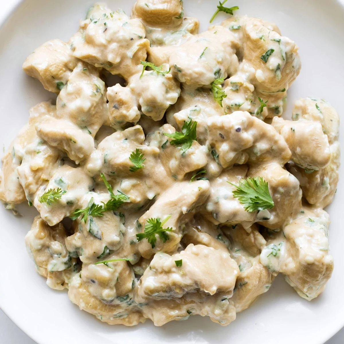 Creamy jalapeño ranch chicken salad with tender chopped chicken, crisp romaine, tomatoes, and cucumbers served in a white bowl.