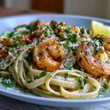 Steaming platter of Shrimp Scampi With Linguine featuring pink shrimp, minced garlic, and bright lemon wedges for a fresh finish.