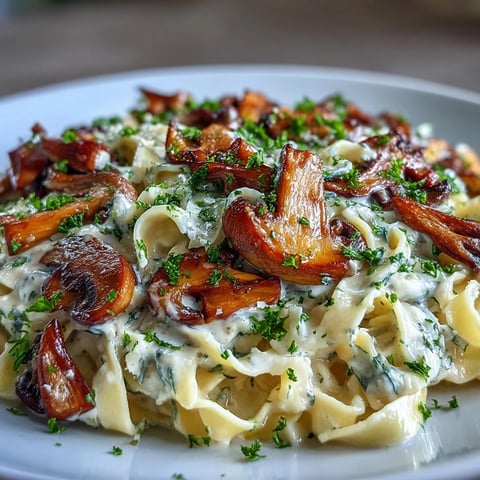 Freshly cooked Creamy Mushroom Stroganoff is served twirled onto a fork, highlighting the rich, tangy miso sauce and tender mushrooms against a rustic wooden table setting.