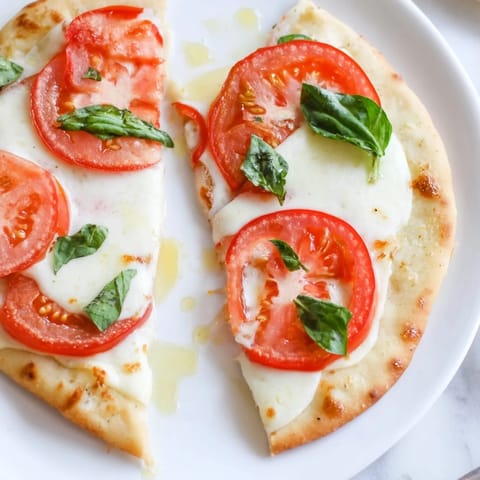 A golden-crusted Quick Margherita Naan Pizza, featuring bubbly cheese and a fragrant aroma filling the plate.