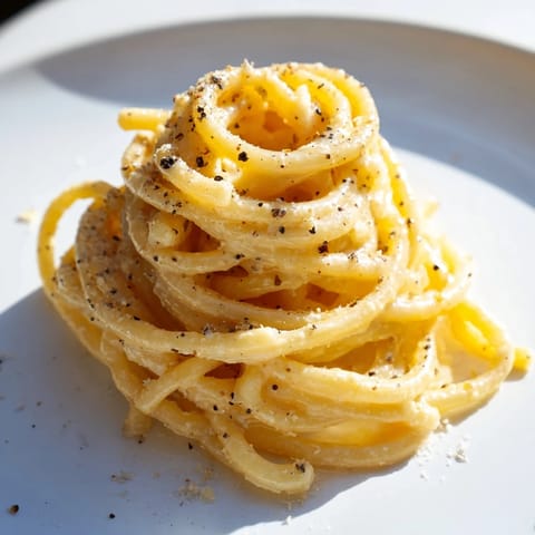 A close-up of steaming Lazy Girl Three-Ingredient Pasta, tossed perfectly with melted butter and cheese.