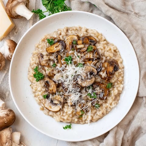 Steaming bowl of homemade Roasted Mushroom Risotto, showcasing tender arborio rice, savory roasted mushrooms, and a glossy Parmesan finish.