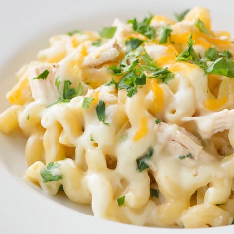 Savory Green Chili Chicken Mac served hot in a rustic skillet, garnished with fresh cilantro and sliced jalapeños for a colorful Southwestern-inspired presentation.  