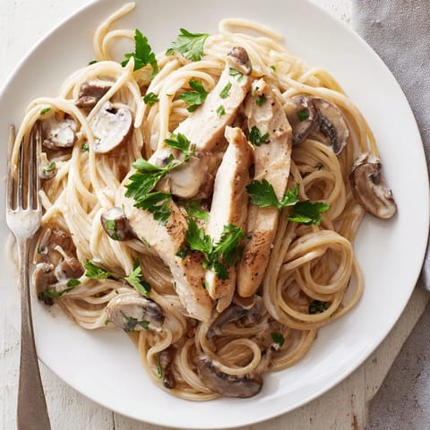Tender sliced chicken and spaghettini twirled in a creamy, velvety mushroom sauce, garnished with fresh parsley and grated Parmesan for a comforting Italian-inspired dinner.  