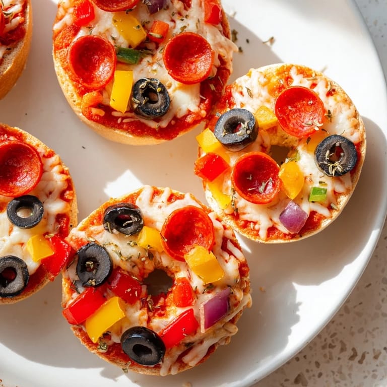 Close-up of freshly air-fried mini bagel pizzas with melted cheese, a simple appetizer.