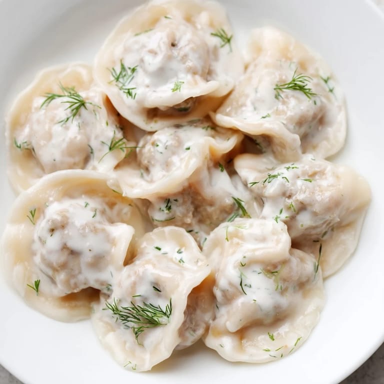 A close-up of a bowl of Russian pelmeni, showcasing the savory meat filling for a hearty meal.