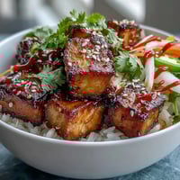Vibrant vegan crispy tofu banh mi bowls with pickled carrots, daikon, and cucumber over jasmine rice.  